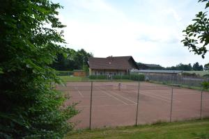 un campo da tennis di fronte a una casa di LummersDorf a Sankt Johann am Wimberg