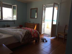 1 dormitorio con 1 cama y puerta a un balcón en Ocean Front Home - Casa Santo Antonio, en São Mateus