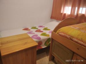 1 dormitorio con cama y mesa de madera en Apartamento centrico, en Santa Pola