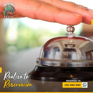 a hand holding a bell on top of a object at Tamarindo Hostel in San Pedro Sula