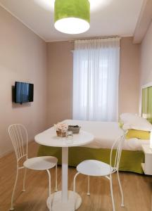 1 dormitorio con 1 cama, mesa y sillas en Myricae, en Matera