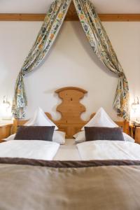 2 camas en un dormitorio con cortinas en la pared en Der Verdinser Hof, en Scena