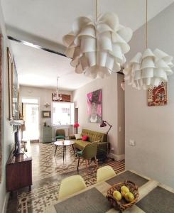 sala de estar con 2 lámparas de araña y mesa en La Casita Vintage, en Madrid