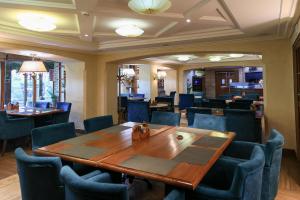 ウラジオストクにあるオーロラ パーク ホテルのダイニングルーム(木製テーブル、青い椅子付)