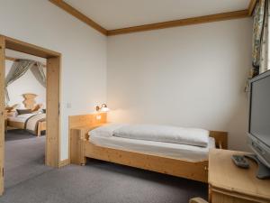 a bedroom with a bed and a television at Der Verdinser Hof in Schenna