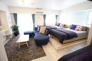 um quarto com 2 camas e um sofá em Condominium Felicita Naha em Naha