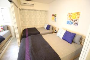 a bedroom with two beds and a couch at Condominium Felicita Naha in Naha