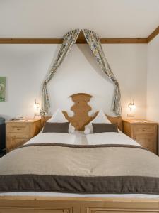 a bedroom with a large bed with a wooden headboard at Der Verdinser Hof in Schenna