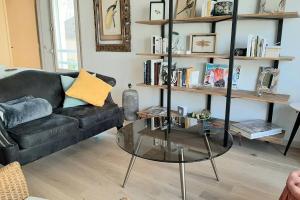 sala de estar con sofá negro y mesa de cristal en Appartement au lac du chateau, en Flers-lez-Lille