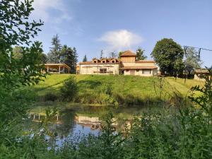 a house sitting on top of a hill next to a lake at Château la bastide cardan in Saint-Sulpice-de-Pommiers