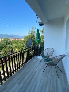 a balcony with a chair and an umbrella at Hostel MAGIJA in Bajina Bašta