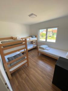 a room with three bunk beds and a window at Hostel MAGIJA in Bajina Bašta