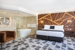 ein Hotelzimmer mit einem Bett und einer Badewanne in der Unterkunft The Gem Hotel in Griffith
