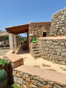 ein Steinhaus mit einer Steinmauer und einer Terrasse in der Unterkunft Trullo "Il fico d'india" in Alliste