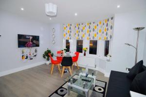 a living room with a table and red chairs at Classy Central Self Contained Flat by CozyNest in Reading