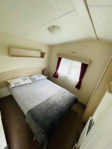 a small bedroom with a bed and a window at Lakeside Holiday Rentals - Delta in Great Billing