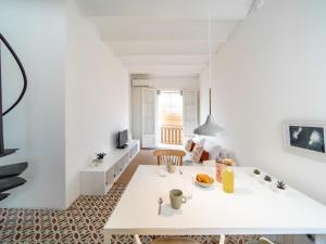 a white living room with a table and a couch at White penthouse in Barcelona
