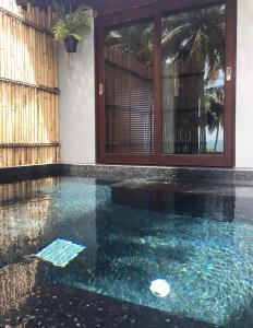 una piscina de agua azul en una casa en Jasmine & Tea House, en Mae Nam