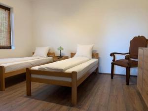 a bedroom with two beds and a chair at Talin Raj in Arandjelovac