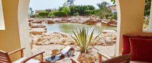 a patio with a pond and a table with chairs at Kempinski Hotel Soma Bay in Hurghada