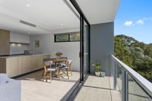 a kitchen and dining room with a balcony with a table at Pinnacle on the Park in Gold Coast