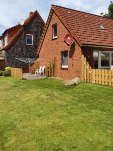 a brick house with a yard and a fence at Ferienhaus Dollartbrise 45005 in Pogum