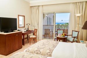 a hotel room with a bed and a desk and a television at Kempinski Hotel Soma Bay in Hurghada