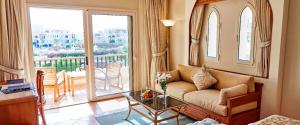 a living room with a couch and a large window at Kempinski Hotel Soma Bay in Hurghada