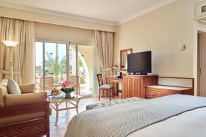 ein Hotelzimmer mit einem Bett und einem TV in der Unterkunft Kempinski Hotel Soma Bay in Hurghada