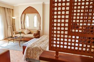 a hotel room with a bed and a living room at Kempinski Hotel Soma Bay in Hurghada