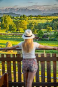 a woman in a hat standing on a bench at Domki w Mizernej, Mizerna 38 nad Jeziorem Czorsztyńskim in Kluszkowce