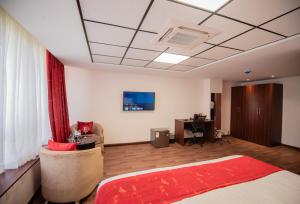 um quarto com uma cama e uma secretária num quarto em The Crossroads Hotel, Westlands em Nairobi