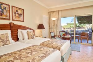 a hotel room with two beds and a balcony at Kempinski Hotel Soma Bay in Hurghada