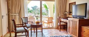 a living room with a television and a table and chairs at Kempinski Hotel Soma Bay in Hurghada