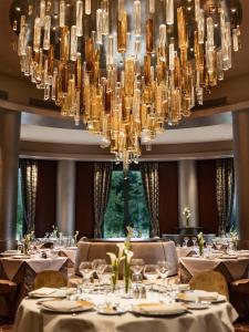 a dining room with tables and chairs under a large chandelier at Disney Hotel New York - The Art of Marvel in Chessy