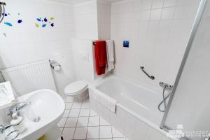 a white bathroom with a toilet and a sink at Appartements Steingasse in Salzburg