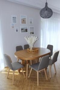 a dining room with a wooden table and chairs at Apartamenty na skraju lasu in Ustka