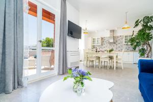 ein Wohnzimmer mit einem weißen Tisch und eine Küche in der Unterkunft Nona's Paradise Apartment - Free parking in Zaton