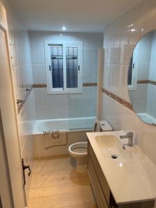 łazienka z umywalką, toaletą i lustrem w obiekcie CASA BURRIANA w mieście Nerja