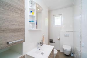 a white bathroom with a sink and a toilet at Nona's Paradise Apartment - Free parking in Zaton +28 photos