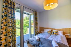 a bedroom with a bed and a balcony at Aparthotel Pod Stokiem z sauną i jacuzzi - Dream Apart in Szczyrk