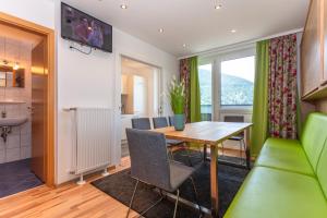 een keuken en eetkamer met een tafel en stoelen bij Appartements am Edthof in Eben im Pongau