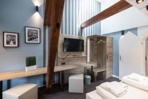 Habitación con paredes azules, TV y sofá. en Oldtown Studios by dasPaul en Núremberg