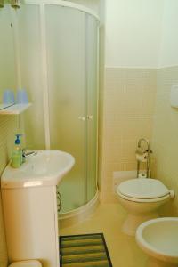 a bathroom with a shower and a toilet and a sink at L'Indià Vittorio Affittacamere in Alghero