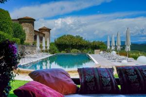 a swimming pool with chairs and umbrellas at Castello Di Gabbiano in Mercatale Val Di Pesa