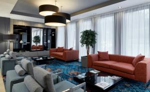 愛丁堡的住宿－Leonardo Edinburgh Murrayfield，客厅配有两张红色的沙发和一张桌子