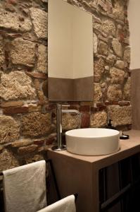 a bathroom with a sink and a stone wall at Covo del Carbonaro in Ascoli Piceno