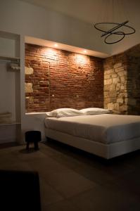 Schlafzimmer mit Ziegelwand und großem Bett in der Unterkunft Covo del Carbonaro in Ascoli Piceno