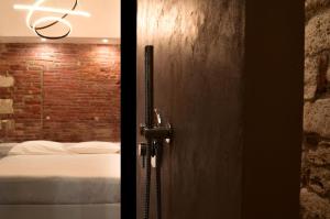 a door to a bedroom with a bed and a brick wall at Covo del Carbonaro in Ascoli Piceno +1 photo