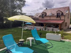 two blue chairs and an umbrella on a yard at villa tsilaocia nabirat in Nabirat